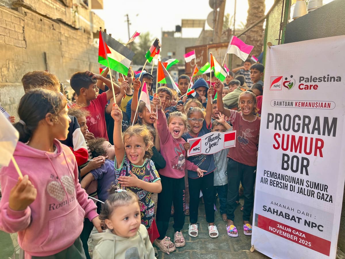 Anak-anak membawa bendera dan papan "Thank you" di samping banner Program Sumur Bor NPC