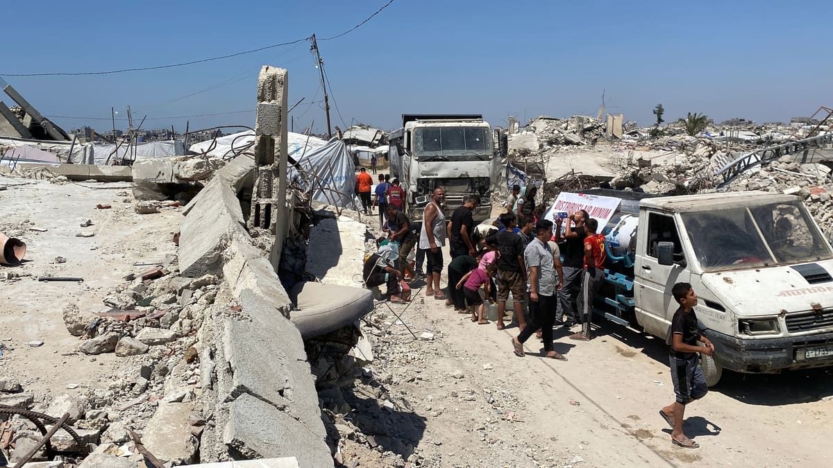 Warga mengambil air dari truk tangki NPC di antara reruntuhan, Gaza City